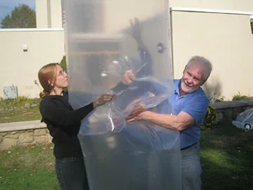 Two Biogas Workshop participants leak testing a poly-bag digester they just manufactured.